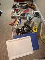 Lot overview showing totes with cables, hand tools including clamps, plane, mitre board and hand saws