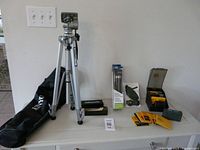 Entire lot displayed on dresser: Velbon tripod with bag, boxed travel tripod, wrist strap, Static Master brush, filter boxes, film safe box