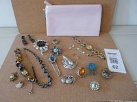 All items laid out with Dior pouch and Guess watch visible