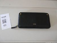 Front view of black Fossil wallet with logo and rivets