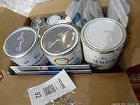 Open box showing Annie Sloan paint cans and sample tins