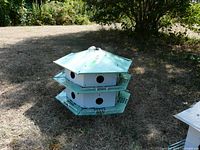 Full view of the stacked two-tier metal birdhouse outdoors