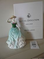 Front view of figurine beside Royal Doulton Pretty Ladies box