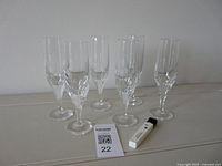 Front view of six champagne flutes and corkscrew