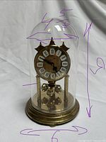 Clock under glass dome showing full piece