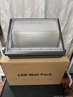 LED wall pack resting on box labelled LED Wall Pack