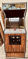 Front view of 1942 arcade cabinet showing marquee, monitor area, control panel, coin door