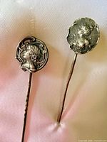 Close-up of two cameo hat pins