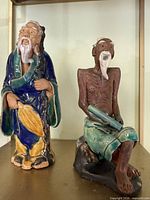 Both Mudman figurines side by side on shelf