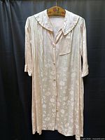 Full view of pale pink satin jacquard robe on hanger