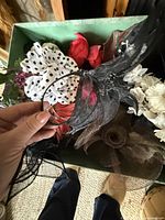 Assorted fascinators and clips held over box showing variety of pieces