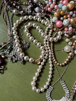 Group of assorted vintage necklaces on green surface
