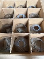 Box containing twelve glass shades separated by cardboard dividers