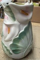 Front view of sculptural ceramic vase with calla lily relief and painted details