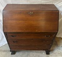 Front view of closed secretary showing three drawers and hardware