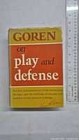 Front cover of the book 'Goren on Play and Defense' by Charles H. Goren, showing the title, author's signature, and color scheme with yellow and orange blocks.