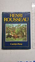 Front cover of the Henri Rousseau art book showing colorful jungle artwork and book title and author.