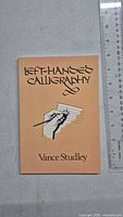 Front cover of 'Left-Handed Calligraphy' book showing title, author, and illustration.