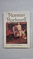 Front cover showing art book titled 'Norman Rockwell' by Elizabeth Miles Montgomery with illustration of man and boys near a car.