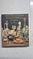 Front cover of The Collector's Encyclopedia: Victoriana to Art Deco book showing various collectible items on display.