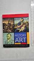 Front cover of the art history book showing several arts including a classical painting of Madonna and Child, a battle scene, and a portrait of Vincent van Gogh.