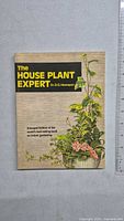 Front cover of 'The House Plant Expert' gardening book showing title, author and plant illustrations.