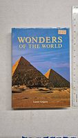 Front cover of the Wonders of the World hardcover book showing pyramids and title.