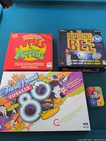 Photo showing the four board games: Apples to Apples, Trivial Pursuit Totally 80s, The Singing Bee, and Zigity.