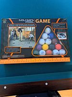 Image of unopened Golfer's Pool Game box showing the included balls and playing instructions
