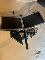 Top view of the triple computer monitor stand showing the three flat screen monitors attached in a triangular configuration with visible mounting arms and central pole.