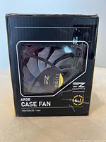 Front photo of the EZ DIY-FAB ARGB computer case fan box, showing the fan through a plastic window and highlighting 6-in-1 ARGB feature and size 120x120x25 mm.