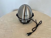 Electric Cuisinart egg cooker assembled with stainless steel dome, black plastic base and power cord
