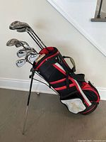 Overall shot of the stand golf bag filled with clubs, showing colors and legs extended for standing support.