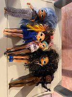 Photo of 5 LOL Surprise dolls showing diverse hairstyles and outfits, posed side by side