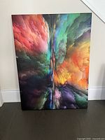 Large abstract artwork on canvas displaying a dynamic multi-color swirling pattern with a central vertical split, showing vibrant colors including red, green, yellow, purple, and blue.