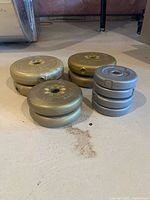 Top view of weight plates grouped by size; two small 2 lbs plates, one 5 lbs, and multiple 10 lbs plates.