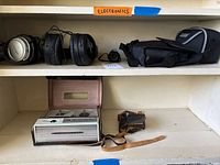 Shelf showing vintage Sony Unicorder 61 reel-to-reel tape recorder with case and leather strap, with Sony and Audio-Technica headphones above