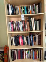 Four shelves filled with books, seen from front capturing the titles and colors on the spines.