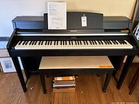 Full view of Casio Celviano AP-620 digital piano with matching bench and sheet music beneath