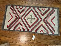 Full front view of rug laid flat on hardwood floor showing complete geometric pattern.