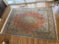 Full view of rug laid out on hardwood floor under sliding glass door