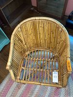 Top down view of rattan bamboo barrel back chair showing woven bamboo back and seat frame.