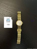 Full frontal view of the gold tone Tissot watch showing the linked bracelet and round dial.