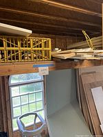 Wide view of loft shelf with lumber, trim, plastic crate