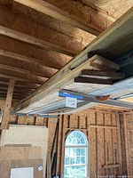 Stack of assorted lumber resting on overhead rack
