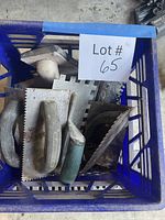 Top view of milk crate showing assortment of trowels, float and chisel