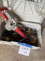 Opened tote containing Milwaukee Hole Hawg drill and assorted bits