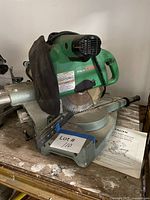 Front angled view of Hitachi C10FS miter saw with manual on table