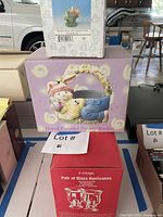 Three sealed boxes showing bunny basket, glass hurricanes, resin figurine