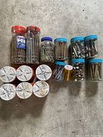 All 16 containers of assorted bolts spread on floor